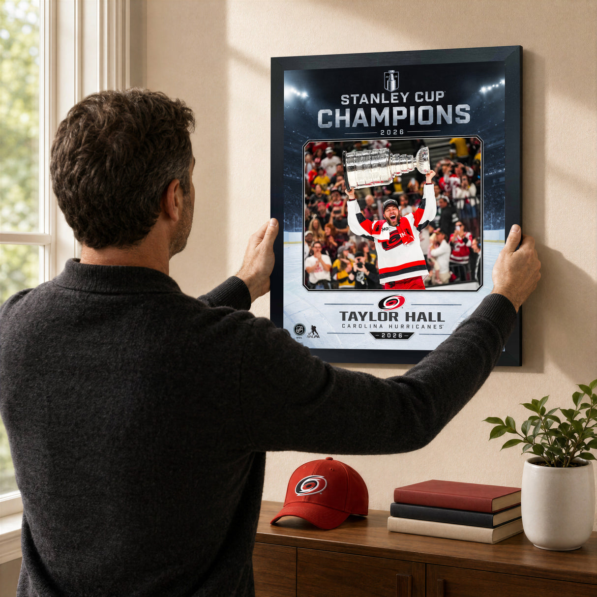Taylor Hall Ice Design 16x20 PhotoGlass frame Carolina Hurricanes 2026 Stanley Cup Champions shown being hung as framed wall art
