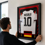 Jamal Musiala framed Germany FIFA World Cup 2026 jersey - Being installed on the wall