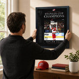 Taylor Hall 16x20 PhotoGlass frame Carolina Hurricanes 2026 Stanley Cup Champions shown being hung as framed wall art