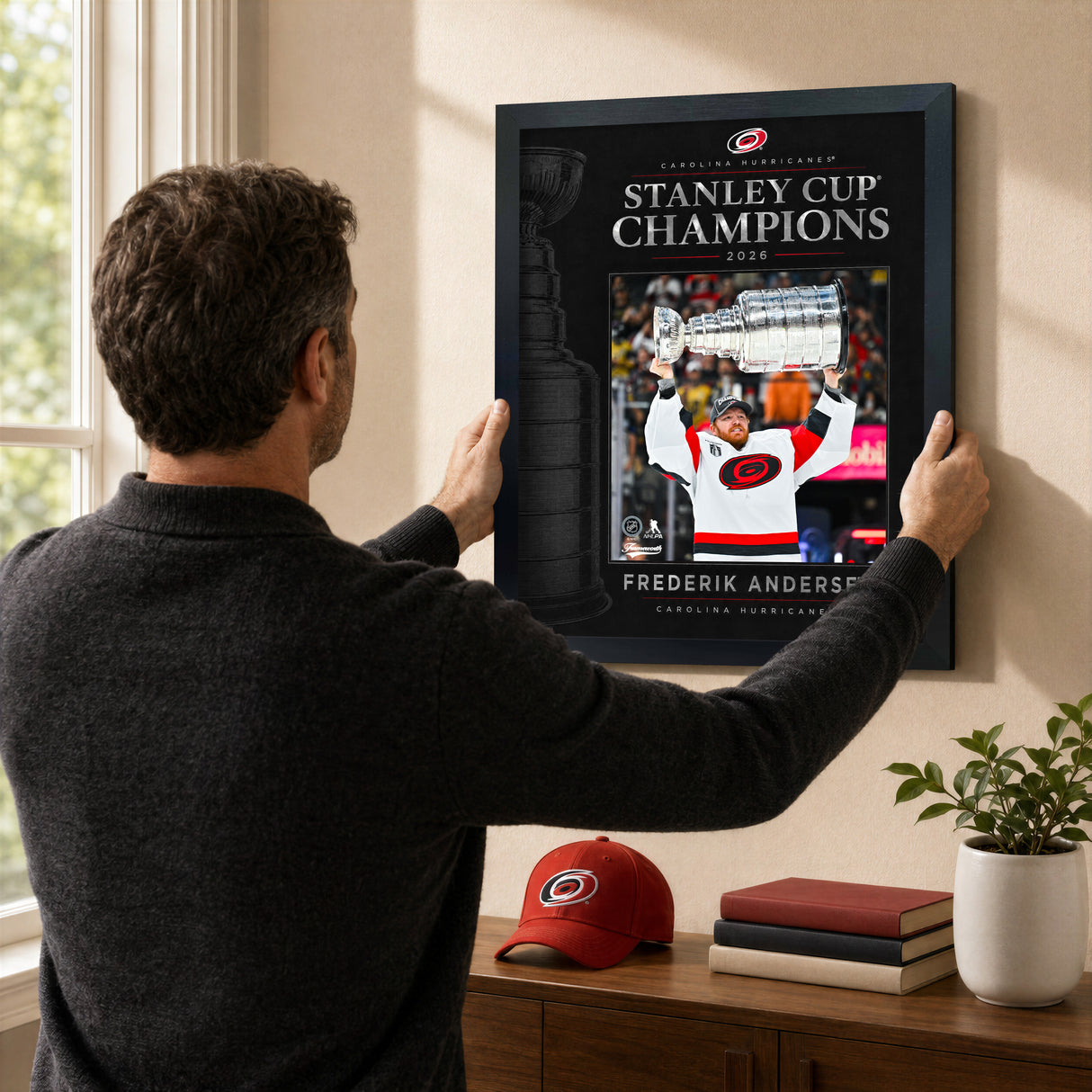 Frederik Andersen 16x20 PhotoGlass frame Carolina Hurricanes 2026 Stanley Cup Champions shown being hung as framed wall art