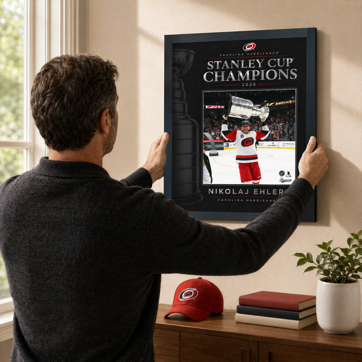 Nikolaj Ehlers 16x20 PhotoGlass frame Carolina Hurricanes 2026 Stanley Cup Champions shown being hung as framed wall art