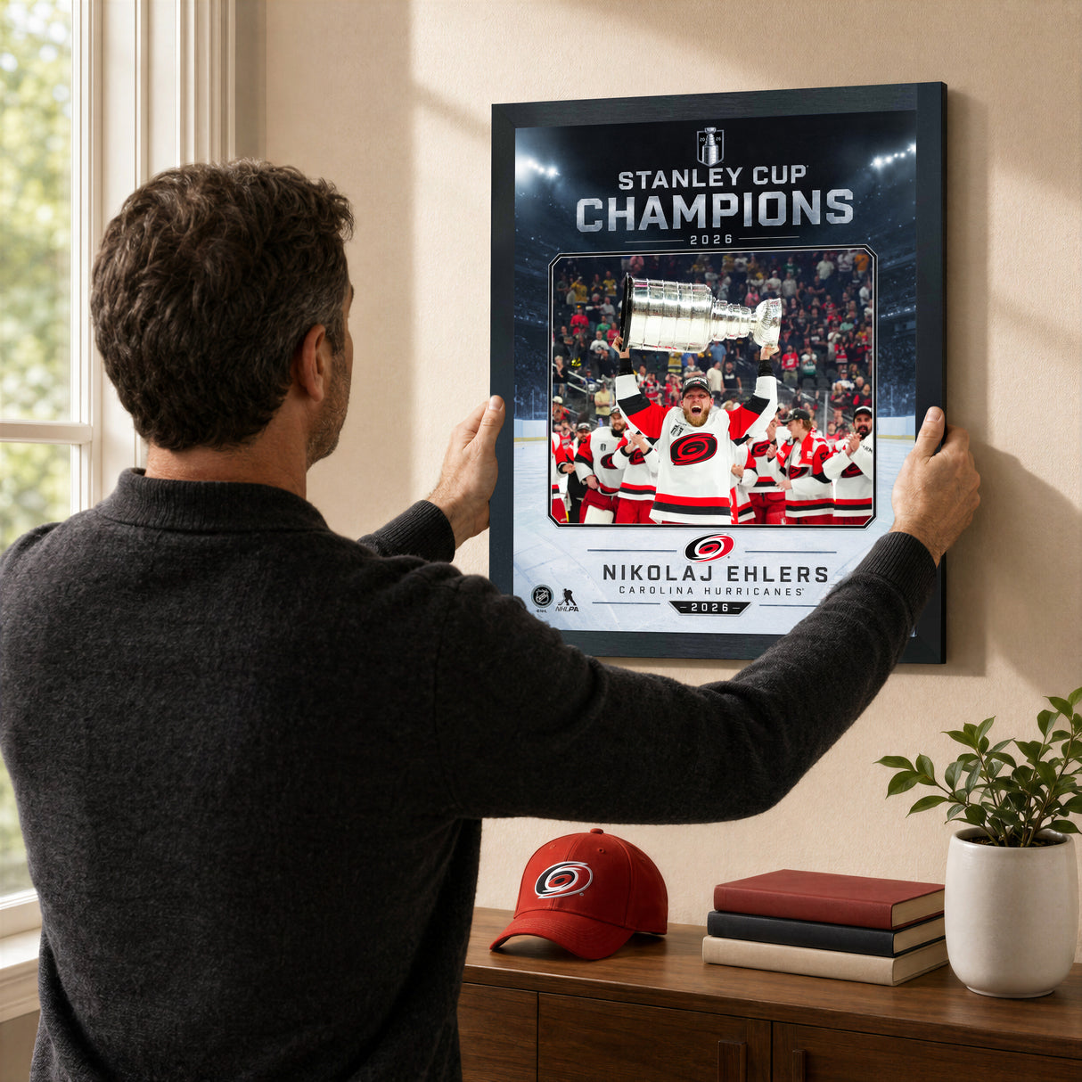 Nikolaj Ehlers Ice Design 16x20 PhotoGlass frame Carolina Hurricanes 2026 Stanley Cup Champions shown being hung as framed wall art