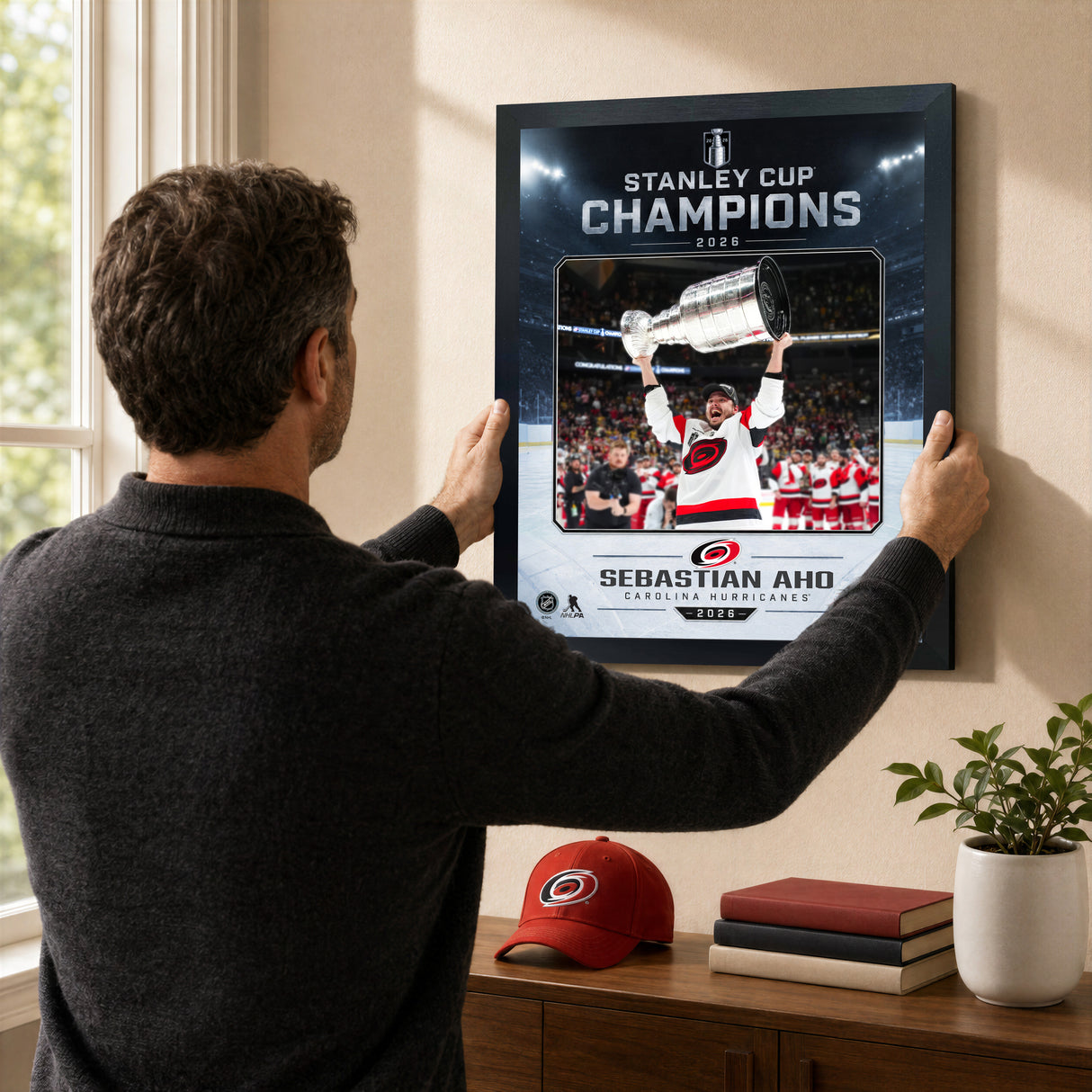 Sebastian Aho Ice Design 16x20 PhotoGlass frame Carolina Hurricanes 2026 Stanley Cup Champions shown being hung as framed wall art