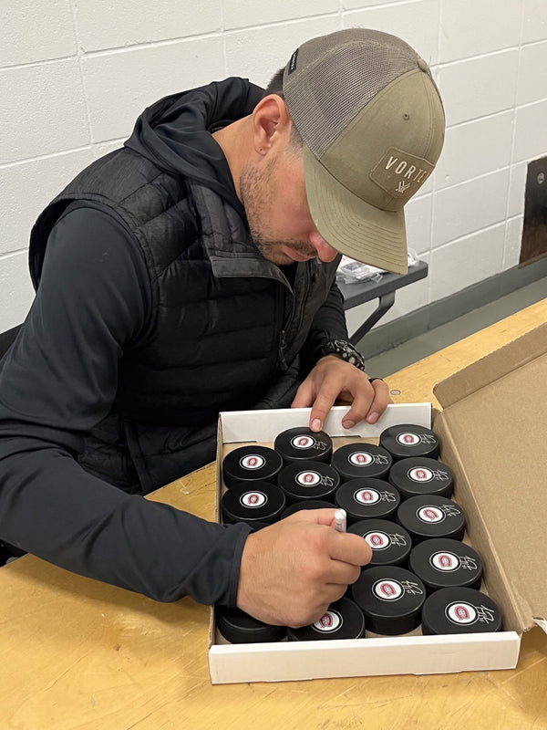 Carey Price signing pucks at a Frameworth signing, 2022